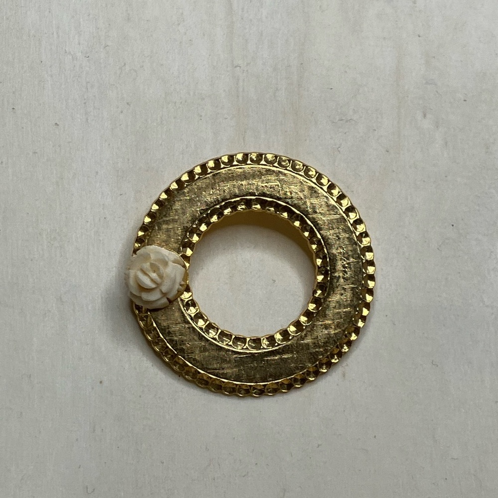 Vintage gold tone crosshatch textured circle brooch with carved celluloid flower